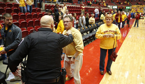 An Iowa State fan upset at the ending of a game against Kansas is restrained by police.