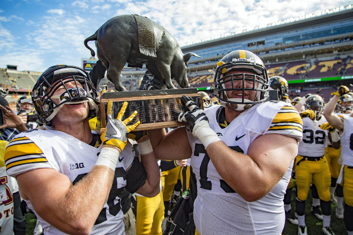 Oct 8, 2016; Minneapolis, MN, USA; Iowa Hawkeyes running back Marcel Joly (26) and Iowa Hawkeyes offensive lineman Ike Boettger (75) hold up the Floyd of Rosedale Trophy after defeating the Minnesota Golden Gophers at TCF Bank Stadium. The Hawkeyes won 14-7. Mandatory Credit: Jesse Johnson-USA TODAY Sports