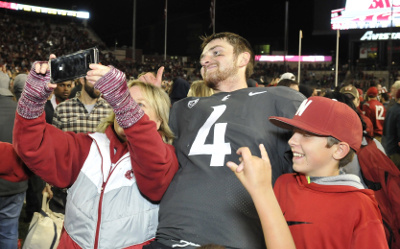 Sep 29, 2017; Pullman, WA, USA; Washington State Cougars quarterback Luke Falk (4) takes a selfie with a fan after a game against the USC Trojans during the second half at Martin Stadium. The Cougars won 30-27. Mandatory Credit: James Snook-USA TODAY Sports