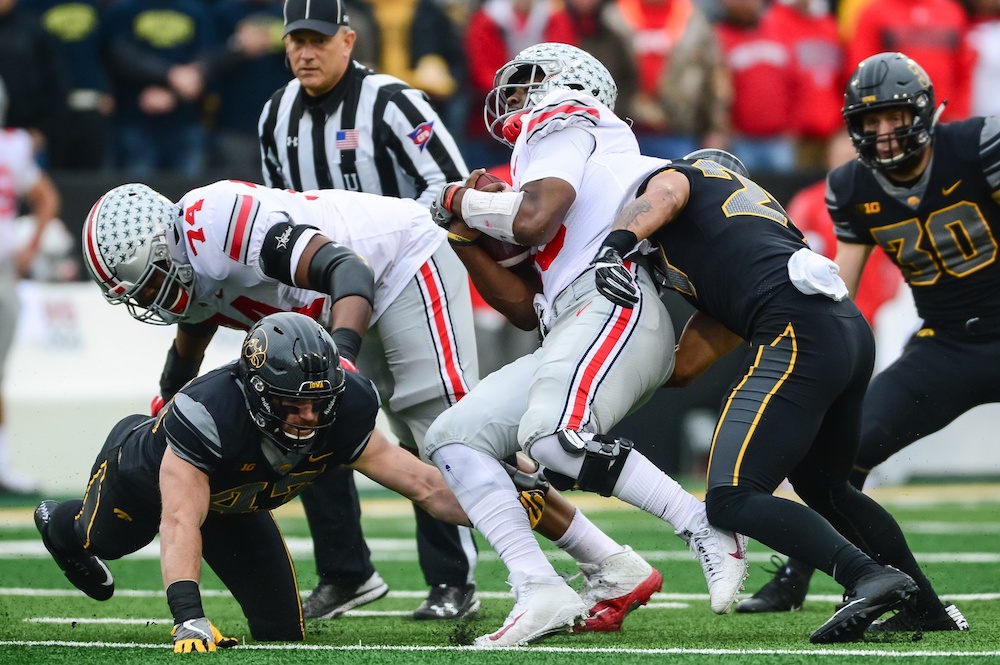 Nov 4, 2017; Iowa City, IA, USA; Ohio State Buckeyes quarterback J.T. Barrett (16) is tackled by Iowa Hawkeyes linebacker Josey Jewell (left) and defensive back Amani Hooker (right) during the first quarter at Kinnick Stadium. Iowa won 55-24. Mandatory Credit: Jeffrey Becker-USA TODAY Sports