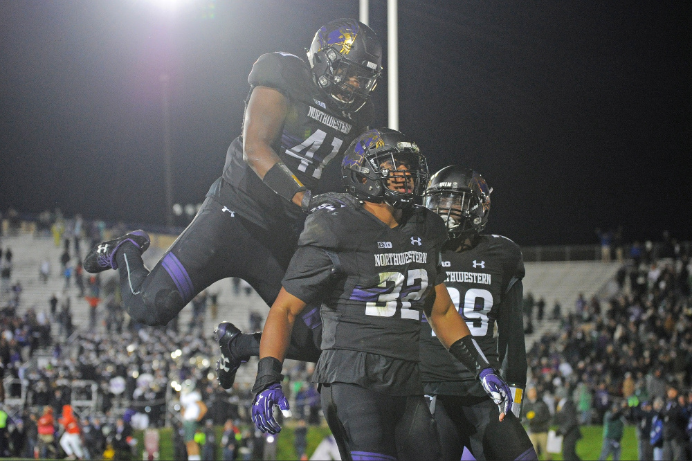 Oct 28, 2017; Evanston, IL, USA; Northwestern Wildcats linebacker Nate Hall (32) celebrates with defensive back Trae Williams (right) and safety Jared McGee (left) after intercepting a pass against the Michigan State Spartans during triple overtime at Ryan Field. The Wildcats won 39-31. Mandatory Credit: Patrick Gorski-USA TODAY Sports