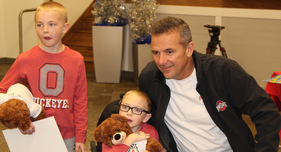 Urban Meyer poses for a photo with a Nationwide Children's Hospital patient and his brother.