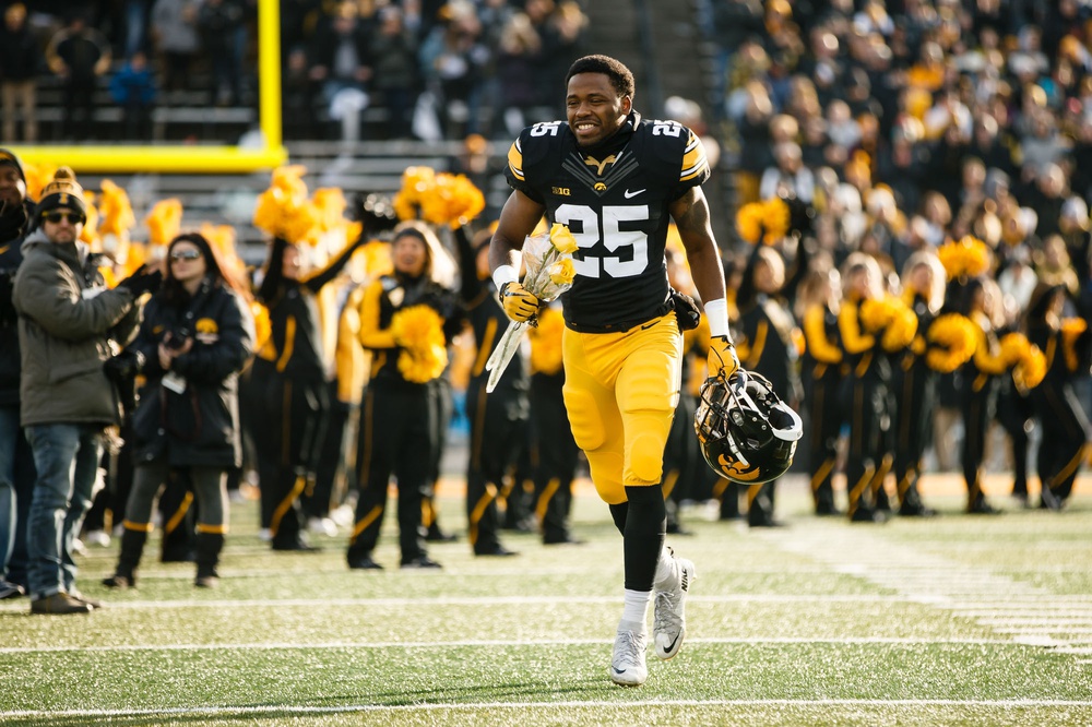 Nov 18, 2017; Iowa City, IA, USA; Iowa player Akrum Wadley (25) runs to greet his parents for senior day before playing Purdue at Kinnick Stadium. Mandatory Credit: Brian Powers/The Des Moines Register via USA TODAY Sports