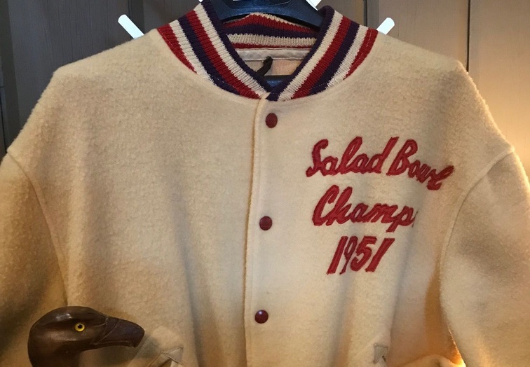 Al Ward's varsity jacket as a member of Woody Hayes' 1950 Miami of Ohio football team that won the Mid-American Conference championship and the Jan. 1 Salad Bowl (now the Fiesta Bowl) over Arizona State. Tucked inside the sleeve of the coat is a walking cane carved by Ward. Salad Bowl
