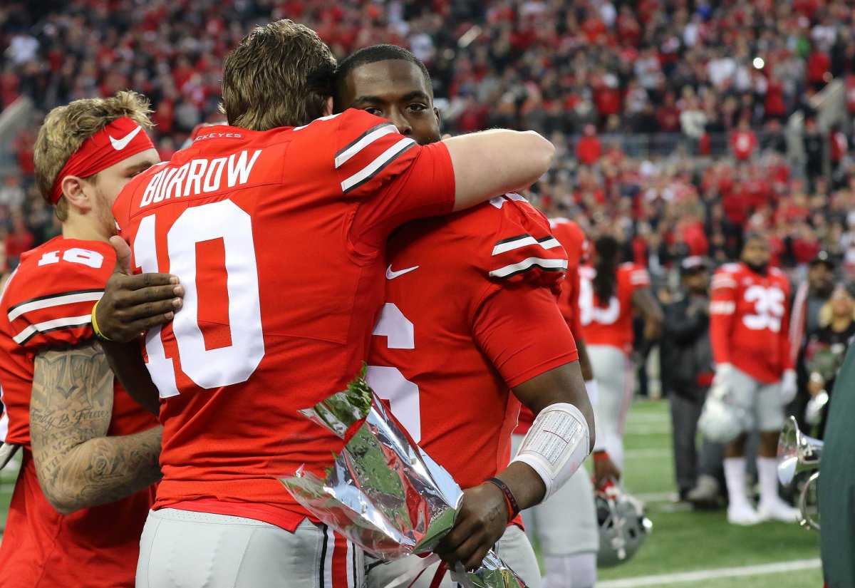 Nov 18, 2017; Columbus, OH, USA; Ohio State Buckeyes quarterback J.T. Barrett (16) hugs Ohio State Buckeyes quarterback Joe Burrow (10) before his final game at Ohio Stadium, against the Illinois Fighting Illini. Mandatory Credit: Joe Maiorana-USA TODAY Sports