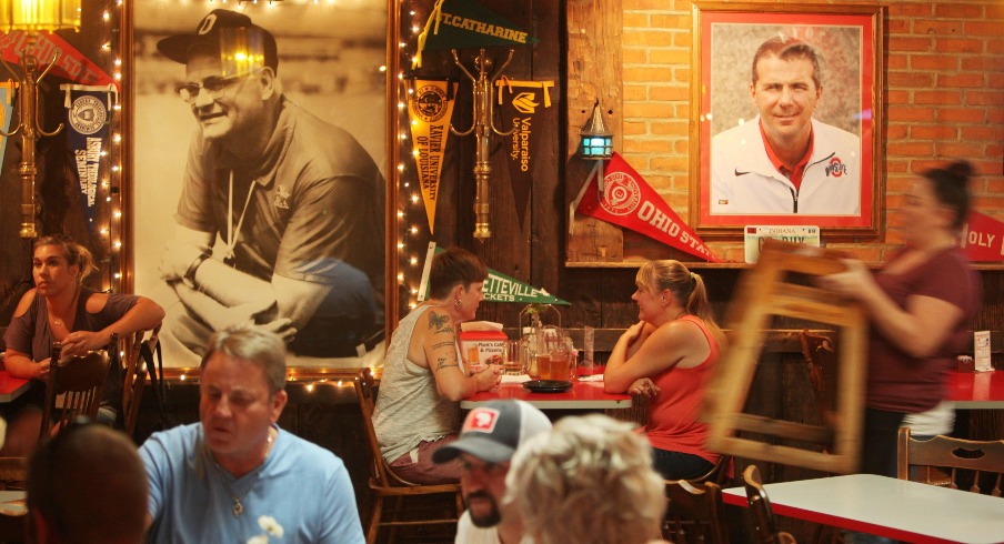 Servers and diners mingle beneath portraits of Woody Hayes and Urban Meyer at Plank's Cafe, 743 Parsons Ave.