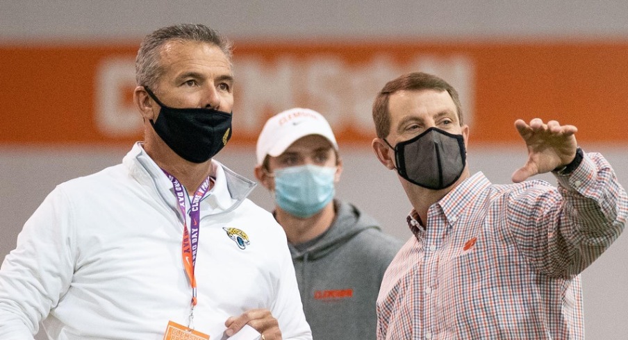 Feb 12, 2021; Clemson, SC, USA; Jacksonville Jaguars head coach Urban Meyer (left) talks with Clemson Tigers head coach Dabo Swinney (right) as quarterback Trevor Lawrence (not pictured) works out during Pro Day in Clemson, South Carolina. Mandatory Credit: David Platt/Handout Photo via USA TODAY Sports