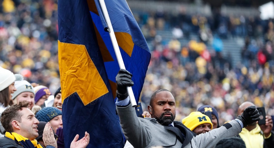 Charles Woodson waves a Michigan flag among fans before the Ohio State game at the Michigan Stadium in Ann Arbor, Saturday, Nov. 30, 2019.