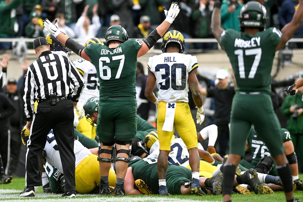 Michigan State's J.D. Duplain, center, celebrates near the pile where Kenneth Walker III scored a touchdown against Michigan during the third quarter on Saturday, Oct. 30, 2021, at Spartan Stadium in East Lansing.
