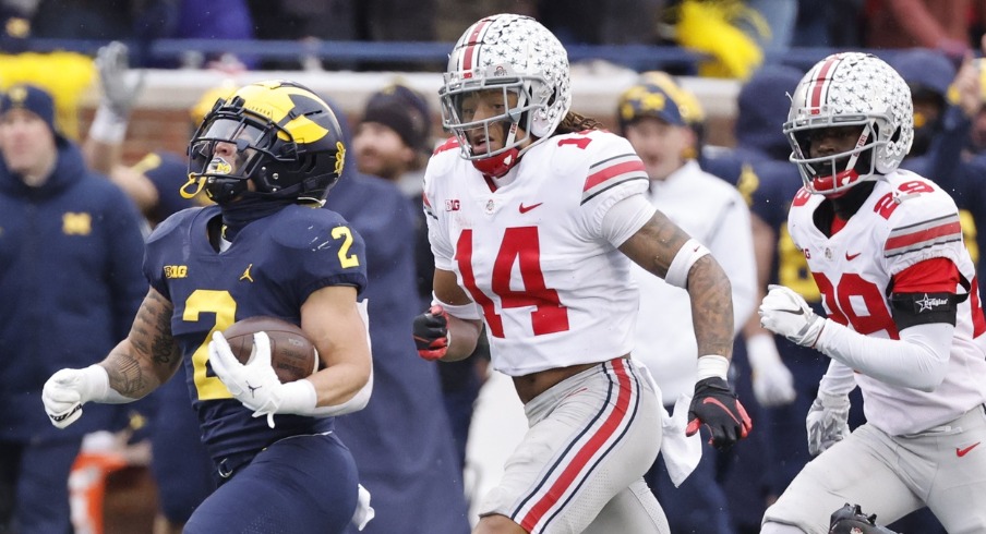 Blake Corum (2) rushes chased by Ohio State Buckeyes safety Ronnie Hickman (14) and ornerback Denzel Burke (29) at Michigan Stadium. Mandatory Credit: Rick Osentoski-USA TODAY Sports