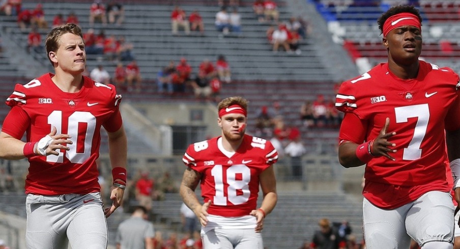 Ohio State Buckeyes quarterbacks, from left, Joe Burrow, Tate Martell and Dwayne Haskins warm up prior to the NCAA football game against the Army Black Knights at Ohio Stadium in Columbus on Sept. 16, 2017.