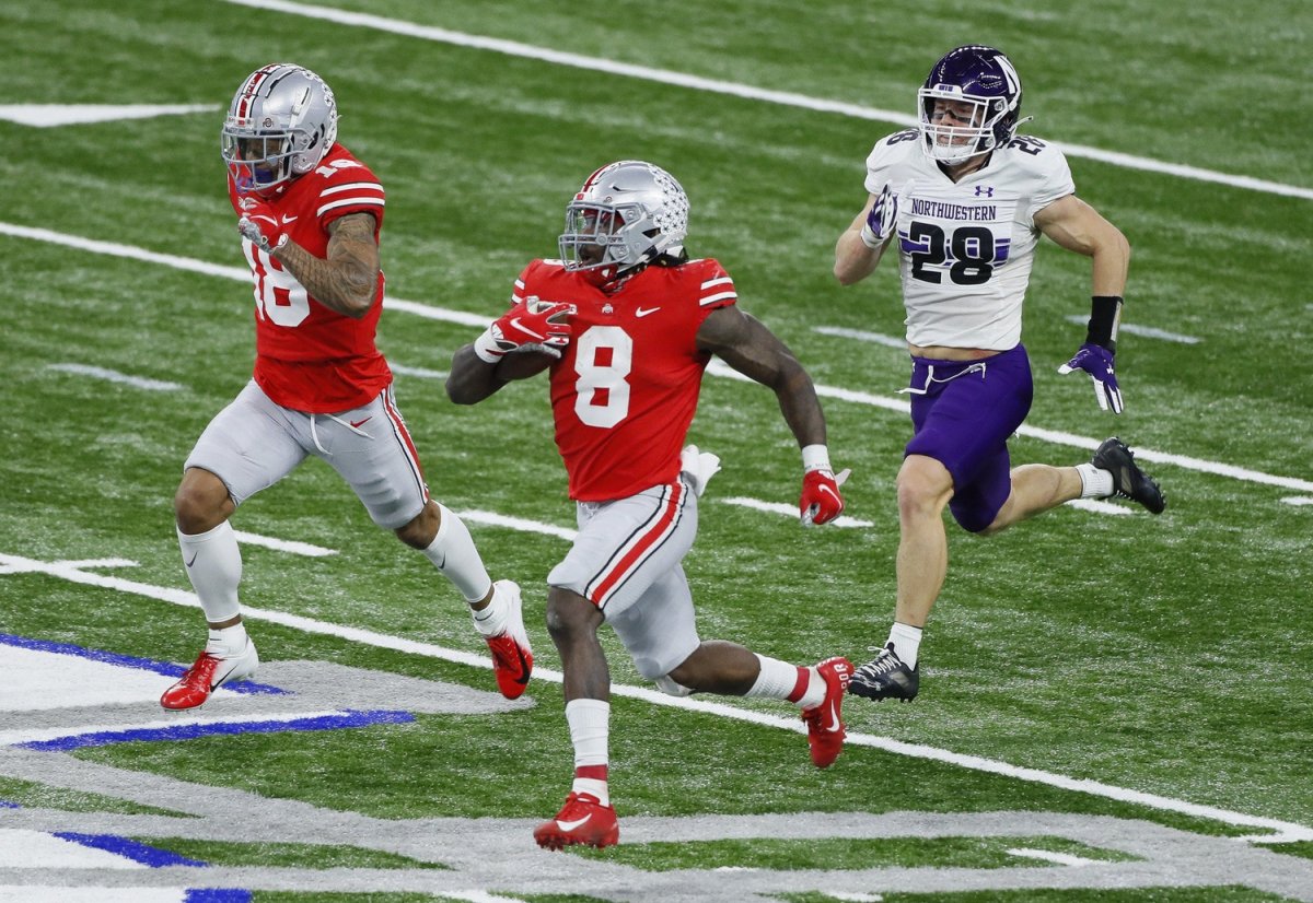 Ohio State Buckeyes running back Trey Sermon (8) rushes for 65 yards alongside wide receiver Kamryn Babb (18) and Northwestern Wildcats linebacker Chris Bergin (28) during the third quarter of the Big Ten Championship football game at Lucas Oil Stadium in Indianapolis on Saturday, Dec. 19, 2020. Ohio State won 22-10. Big Ten Championship Ohio State Northwestern
