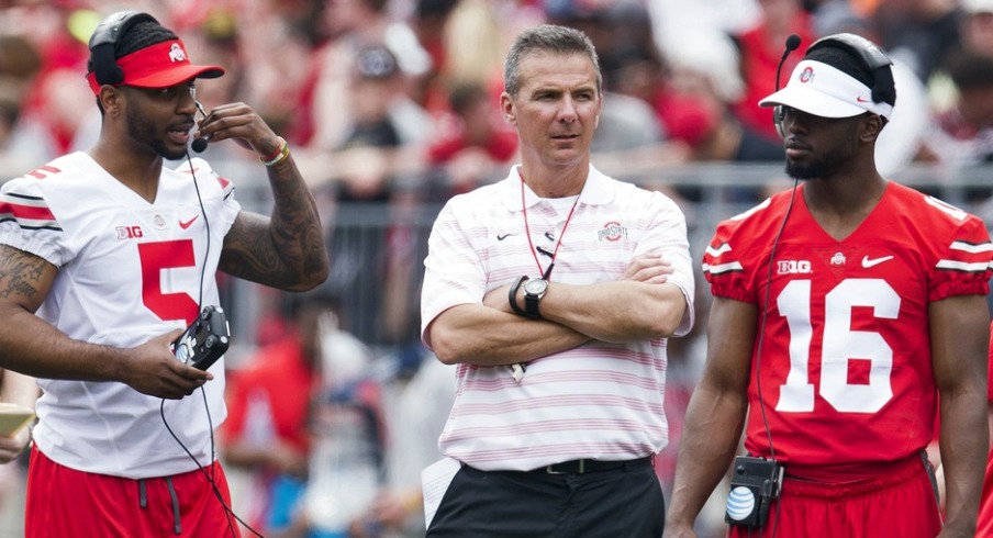 Apr 18, 2015; Columbus, OH, USA; Ohio State Buckeyes quarterback Braxton Miller (5) head coach Urban Meyer and quarterback J.T. Barrett (16) talk on the field during the Ohio State Spring Game at Ohio Stadium. The Gray team won the game 17-14.