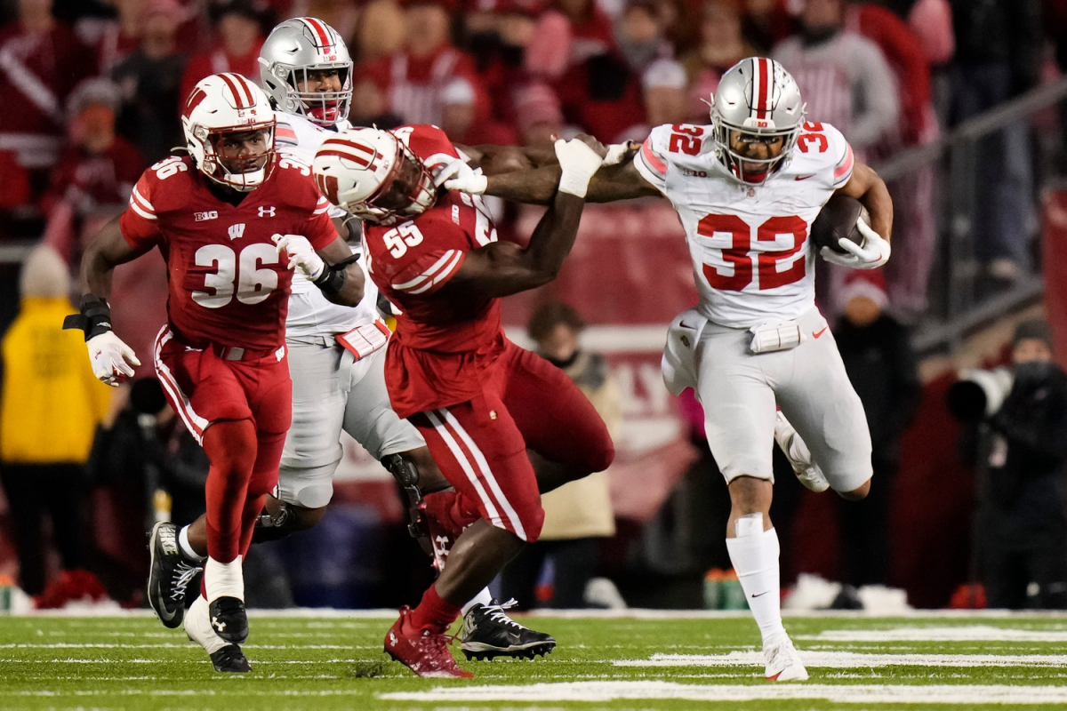 Oct 28, 2023; Madison, Wisconsin, USA; Ohio State Buckeyes running back TreVeyon Henderson (32) runs through Wisconsin Badgers linebacker Maema Njongmeta (55) during the second half of the NCAA football game at Camp Randall Stadium. Ohio State won 24-10.