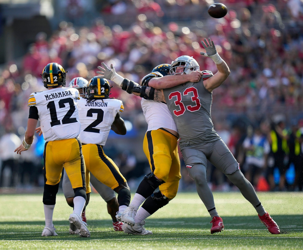 Oct 5, 2024; Columbus, OH, USA;Iowa Hawkeyes quarterback Cade McNamara (12) gets a pass off against Ohio State Buckeyes defensive end Jack Sawyer (33) in the second quarter during the NCAA football game at Ohio Stadium.