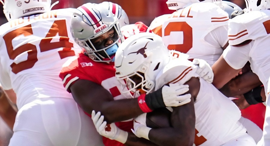 Ohio State Buckeyes defensive lineman Kayden McDonald (98) tackles Texas Longhorns running back CJ Baxter (4) during the NCAA football game at Ohio Stadium on Aug. 30, 2025.