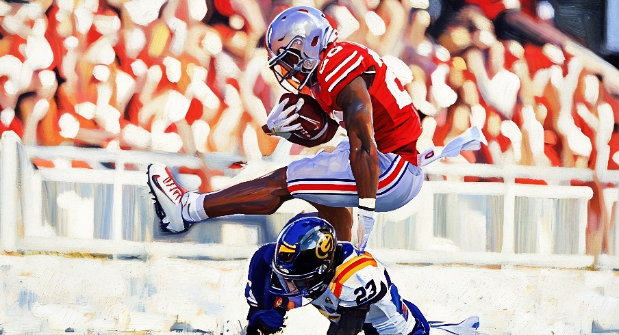 Ohio State Buckeyes running back James Peoples (20) leaps over Grambling State Tigers defensive back Jalen Guillard (23) in the second half of the NCAA football game at the Ohio Stadium on Saturday, Sept. 6, 2025 in Columbus, Ohio