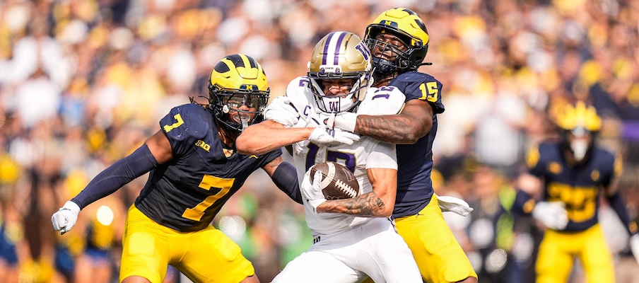 Denzel Boston getting tackled by two Michigan defenders Denzel Boston getting tackled by two Michigan defenders
