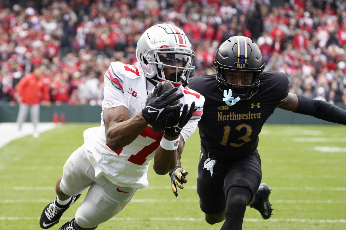 Nov 16, 2024; Chicago, Illinois, USA; Ohio State Buckeyes wide receiver Carnell Tate (17) catches a touchdown pass as Northwestern Wildcats defensive back Josh Fussell (13) defends during the first half at Wrigley Field. Mandatory Credit: David Banks-Imagn Images