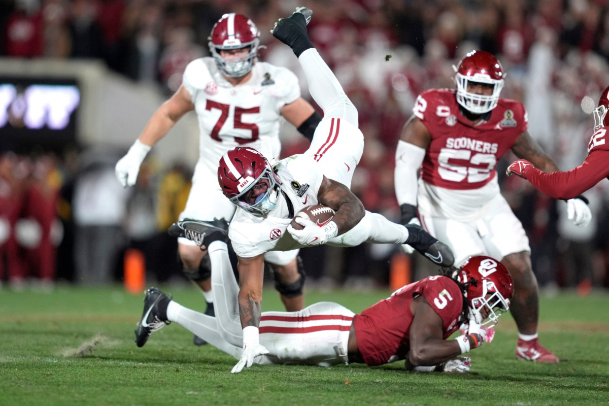 Alabama Crimson Tide running back Daniel Hill (4) ;eaps over Oklahoma Sooners linebacker Kendal Daniels (5) during a first-round College Football Playoff game between the University of Oklahoma Sooners (OU) and the Alabama Crimson Tide at Gaylord Family – Oklahoma Memorial Stadium in Norman, Okla., Friday, Dec. 19, 2025. Alabama won 34-24. Alabama Crimson Tide running back Daniel Hill (4) ;eaps over Oklahoma Sooners linebacker Kendal Daniels (5) during a first-round College Football Playoff game between the University of Oklahoma Sooners (OU) and the Alabama Crimson Tide at Gaylord Family – Oklahoma Memorial Stadium in Norman, Okla., Friday, Dec. 19, 2025. Alabama won 34-24.