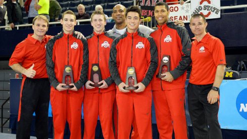 Men's gymnastics team with trophies