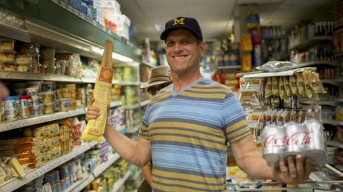 Jim Harbaugh in France, showing off some groceries.