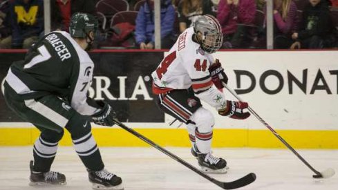 Ohio State's Anthony Greco skates by John Draeger of Michigan State.