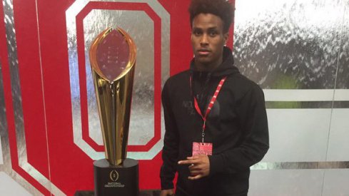 Kareem Felder poses next to Ohio State's national championship trophy