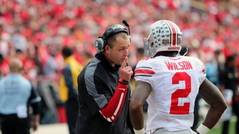 Zach Smith speaks with Dontre Wilson on the sideline.