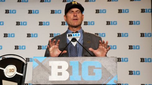 Fortune teller Jim Harbaugh performs at the B1G Football Media Carnival.