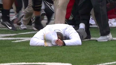 Urban Meyer lies on the ground motionless after his Buckeyes topped No. 3 Michigan in double overtime