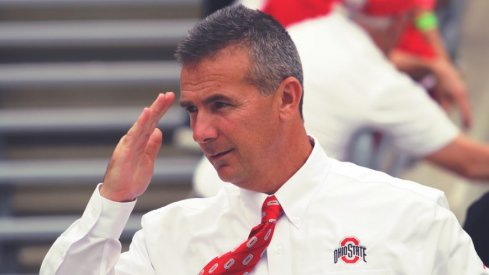 Urban Meyer salutes before a game.