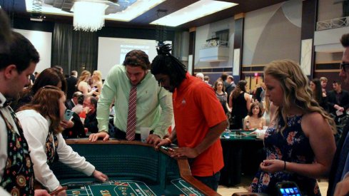 Nick Bosa and Damon Arnette play craps at ATO casino night.