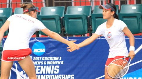 Sophomore Francesca Di Lorenzo and senior Miho Kowase high five after a doubles match.