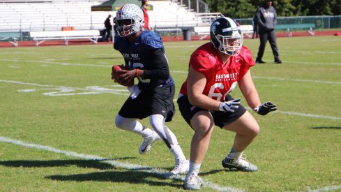 Ohio State quarterback J.T. Barrett takes a snap from Michigan State center Brian Allen during the first day of East-West Shrine Game practice.