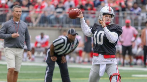 Urban Meyer looks on as Joe Burrow throws a pass.