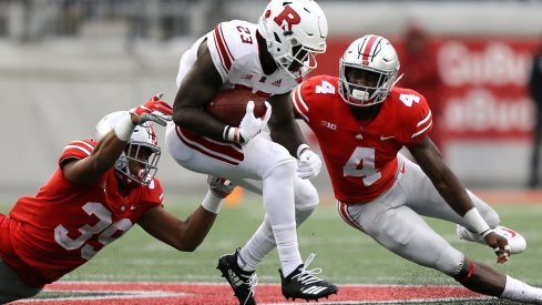 Jordan Fuller and Malik Harrison combine for a tackle against a Rutgers ballcarrier. 