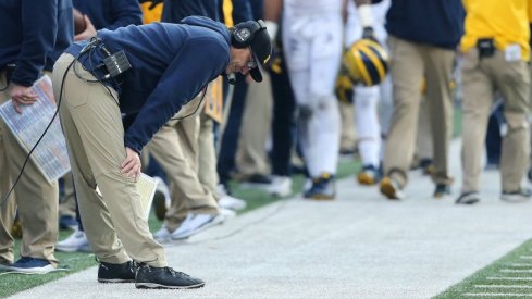 Jim Harbaugh inspects the ground in Ohio Stadium. 