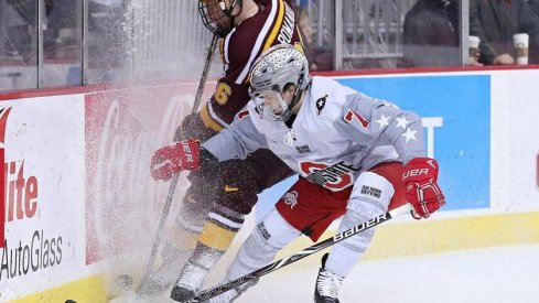 Buckeye defenseman Wyatt Ege battles Minnesota's Darian Romanko in the Gopher's 4-3 win over Ohio State.