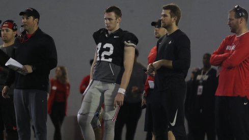 Matthew Baldwin watches a play alongside members of Ohio State's coaching staff during spring practice.