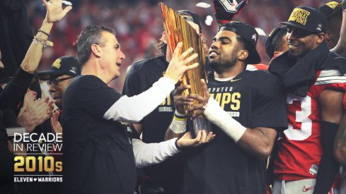 Urban Meyer hands the national championship trophy for the 2014 season to Ezekiel Elliott.