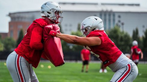 Tight ends run through a blocking drill in practice.