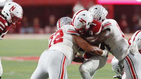 Tommy Togiai (72) and Dallas Gant tackle Nebraska's Wan'Dale Robinson