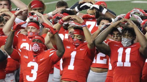 Justin Fields celebrates a 49-27 win over Rutgers with Demario McCall and Tyreke Smith.