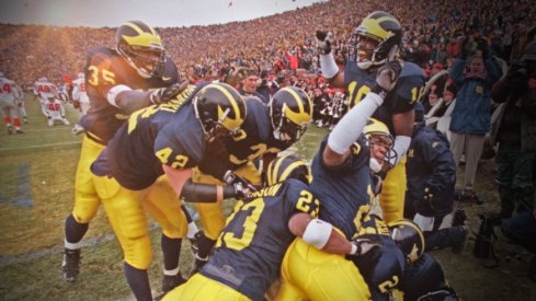 Michigan cornerback Charles Woodson is mobbed by celebrating teammates after his 2nd quarter punt return for a touchdown against Ohio State University on Saturday, Nov 22, at Michigan Stadium in Ann Arbor, MI