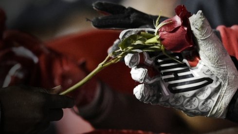 Jan 1, 2019; Pasadena, CA, USA; Ohio State Buckeyes quarterback Dwayne Haskins Jr. (left) hands out roses after defeating the Washington Huskies in the 2019 Rose Bowl at Rose Bowl Stadium. Mandatory Credit: Kelvin Kuo-USA TODAY Sports