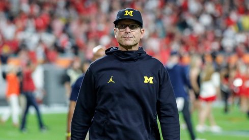 Jim Harbaugh walks off after a College Football Playoff loss