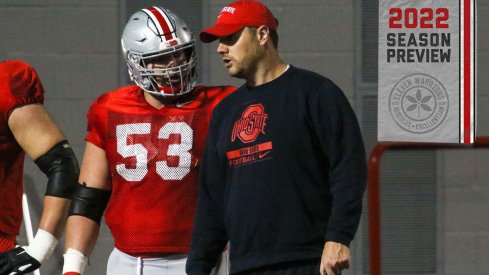 Ohio State offensive line coach Justin Frye speaks with center Luke Wypler during practice
