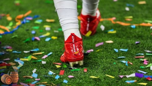 December 7, 2019;  Indianapolis, IN, USA;  A view of the Nike cleats worn by Ohio State Buckeyes defensive end Chase Young (2) as he walks through confetti after defeating the Wisconsin Badgers in the 2019 Big Ten Championship Game at Lucas Oil Stadium.  Mandatory credit: Aaron Doster-USA TODAY Sports