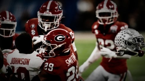 Dec 31, 2022; Atlanta, Georgia, USA; Ohio State Buckeyes wide receiver Xavier Johnson (10) loses his helmet while being tackled by Georgia Bulldogs defensive back Christopher Smith (29) during the second quarter of the 2022 Peach Bowl at Mercedes-Benz Stadium. Mandatory Credit: Dale Zanine-USA TODAY Sports